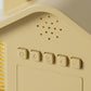 Yellow house-shaped digital alarm clock control panel with buttons and small status icons