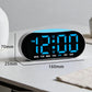 Digital alarm clock with blue LED time display and rounded black body