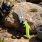 Compact fishing scissors/pliers with lime green handle, black finger loop, and metal cutting jaws