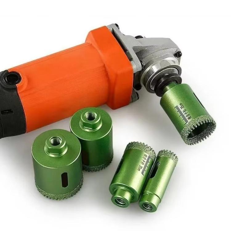 Green tile hole saw bits with serrated diamond edge attached to a drill