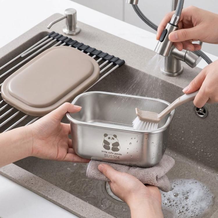 Stainless steel mini container being cleaned by hand with beige lid on sink