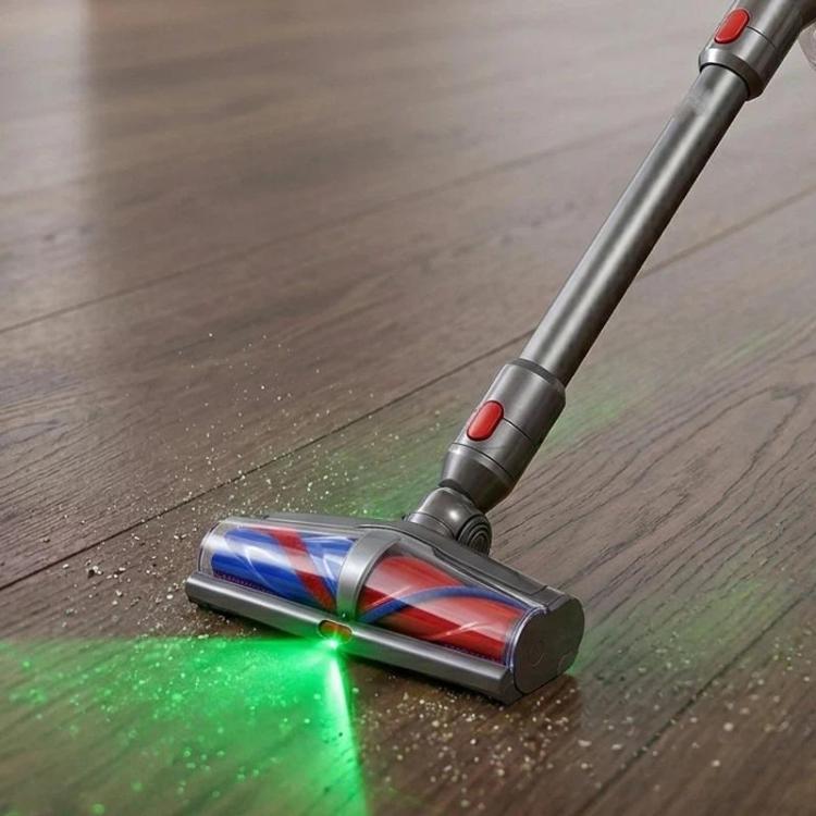 Motorized floor brush running on wood floor with green LED dust detection glow