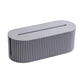 Desktop wire management cable box with open top slot, gray ribbed body and rounded top.