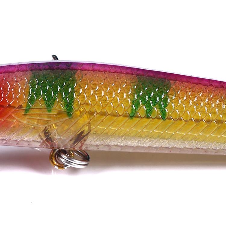 Close-up side view of gold-green minnow lure scales with treble hook