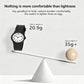 Black analog wristwatch on balance scale, rubber strap and round white dial