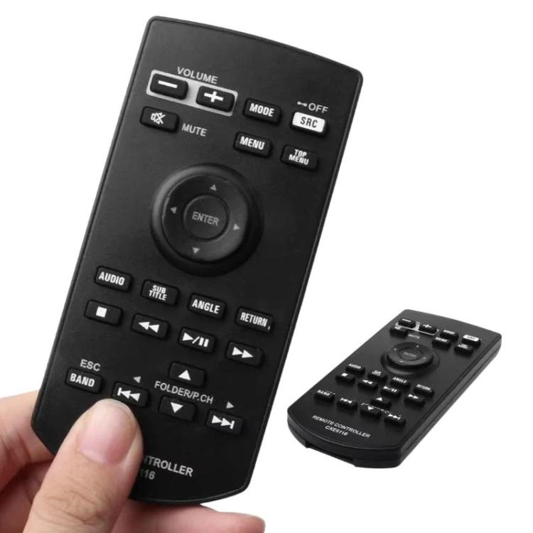 Black car audio DVD remote controller held in hand; second remote beside it