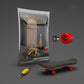 Finger skateboard toy with red wheels and wooden deck, shown in retail box