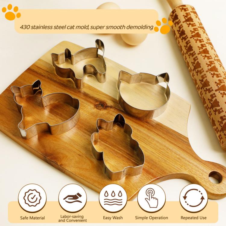 Stainless steel cat cookie molds arranged on a wooden board with rolling pin nearby
