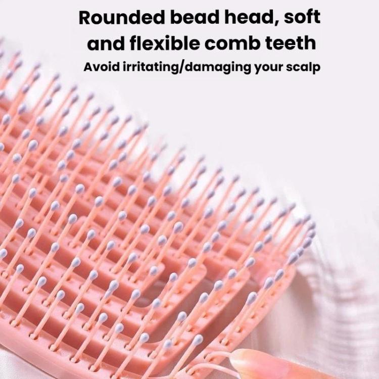 Close-up of pink comb teeth on rounded hollow hair massage brush head