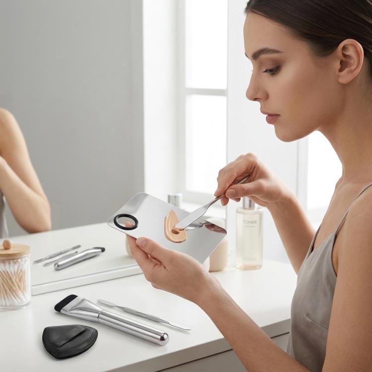 Makeup mixing tools set with foundation brush, spatulas, and powder puff on vanity