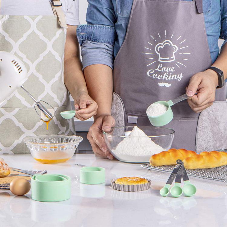 Mint green silicone measuring spoons on kitchen prep table with stainless tools