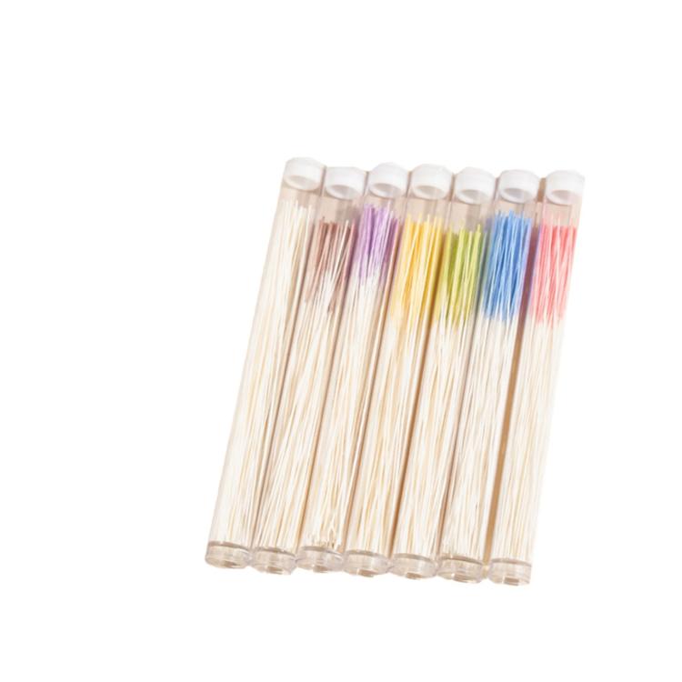 Bundle of disposable ear cleaning thread sticks with colored ends in clear plastic tubes