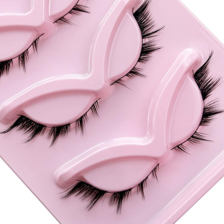 Close-up of black false eyelashes with curled tips on a pink molded backing