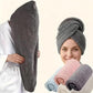 Dark gray hair drying cap worn on head with folded pastel towels