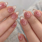Short almond press-on nails in translucent pink jelly with glossy ombre glitter and sparkle