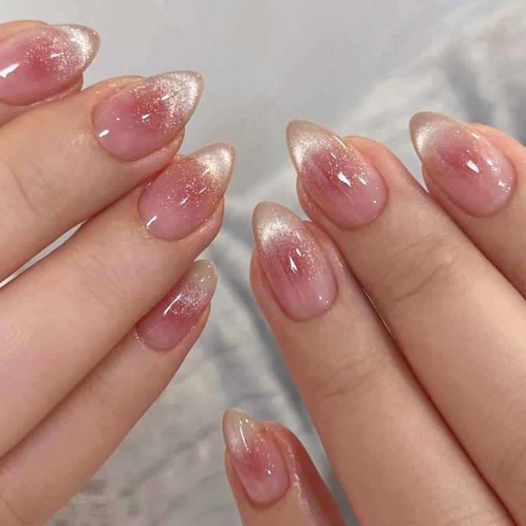 Short almond press-on nails in translucent pink jelly with glossy ombre glitter and sparkle