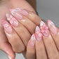 Pink ombre almond fake nails with 3D flowers, bows, and dot detailing