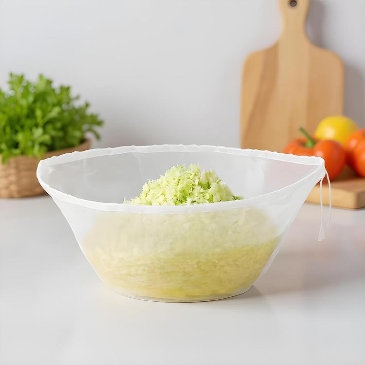 Large bowl-shaped strainer bag filled with shredded vegetables in pale mesh