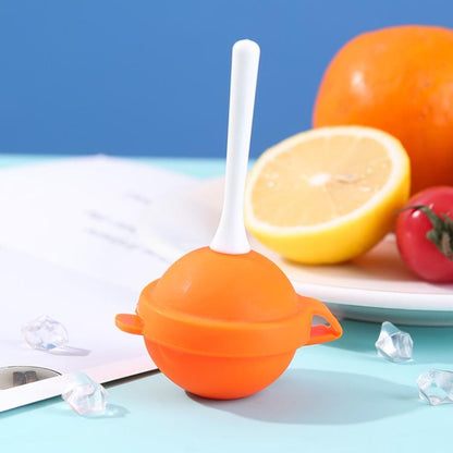 Lollipop-shaped ice pop mold with orange round silicone shell and white stick