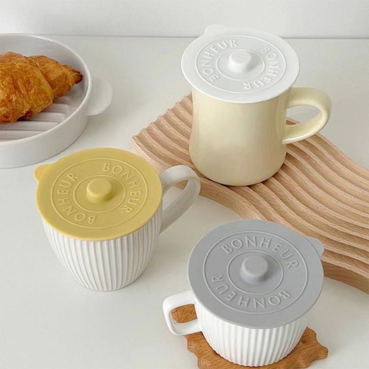 Round silicone pot lids set in gray, yellow, and white with central raised knob