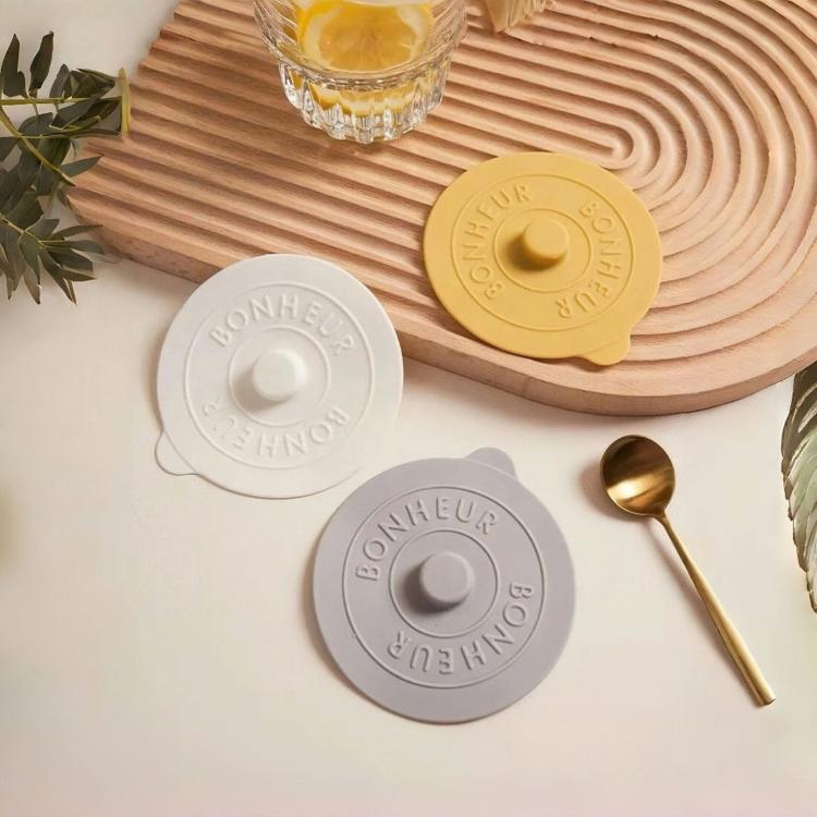 Round silicone lids set in white, yellow, and gray, each with embossed center knob