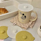 White round silicone lid with central knob and embossed BONHEUR text