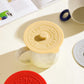 Yellow round silicone lid with central knob and embossed BONHEUR text