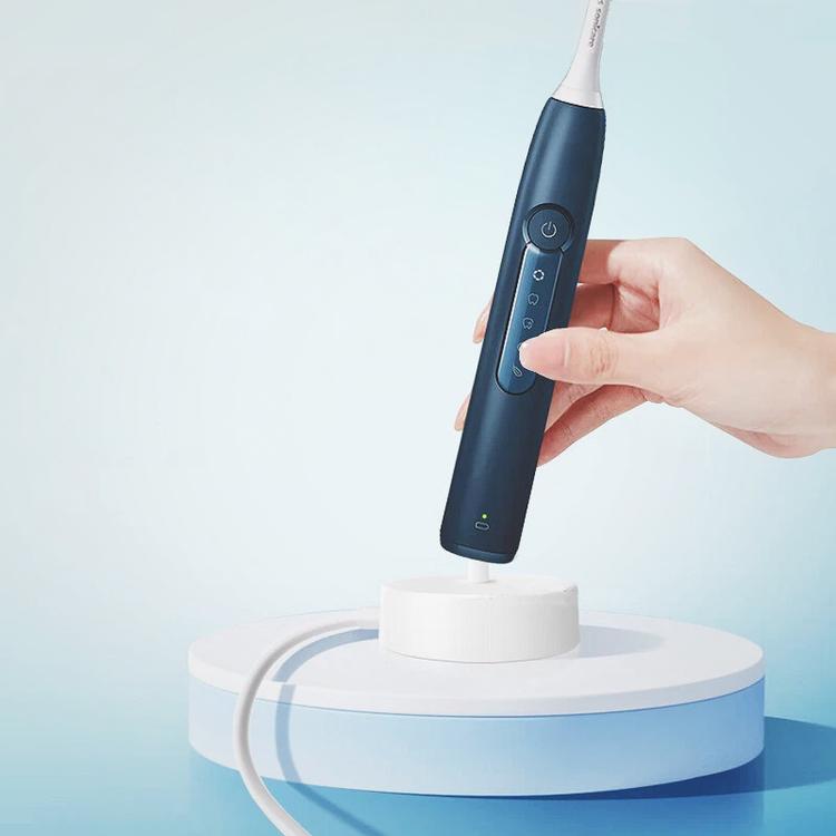 USB charging dock with toothbrush handle on top, status lights on