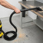 Black extension tube set held with flexible vacuum hose for floor cleaning