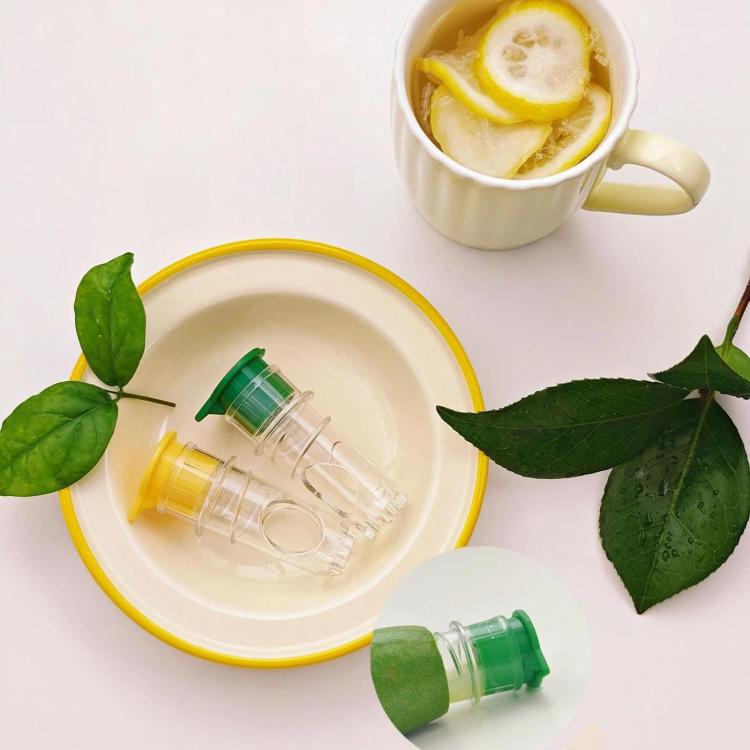 Two-piece manual citrus juicer set with clear chambers, green and yellow caps.