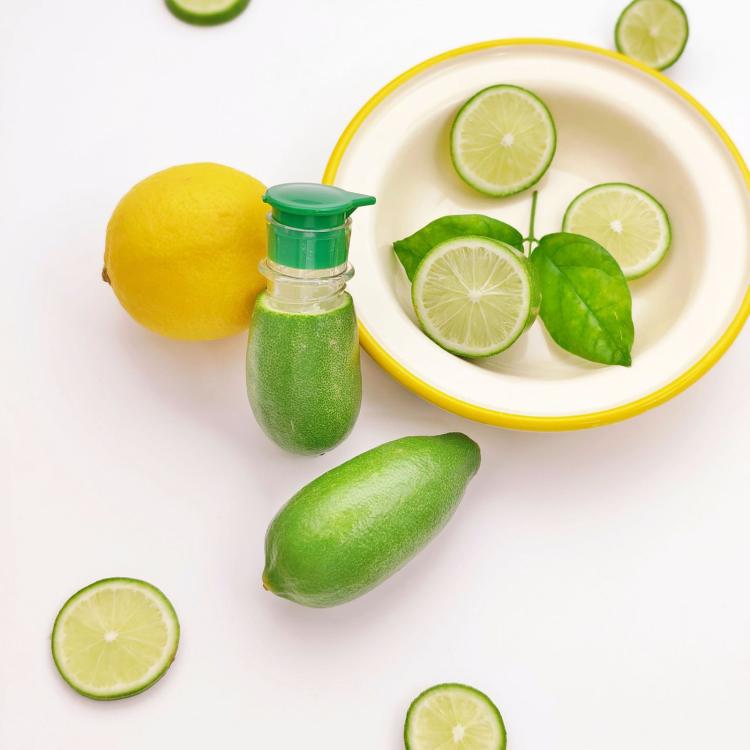 Manual citrus juicer bottle with green lid and clear chamber.