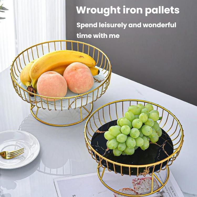 Two round wrought iron fruit trays with gold frames, holding bananas, peaches, and grapes.