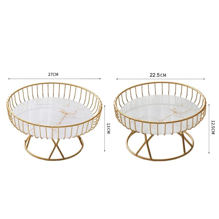 Two round wrought iron fruit trays with gold frames and white inserts in small and large sizes.