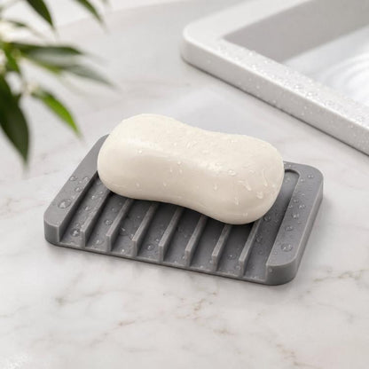 Gray silicone soap dish with raised ridges holding a white bar of soap