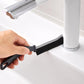 Flat crevice cleaning brush used to scrub hard-to-reach gaps near a sink