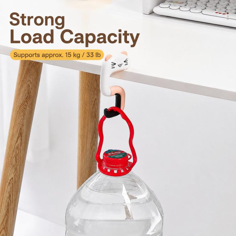 Cat-shaped table bag hook holding a small red bag loop on desk.