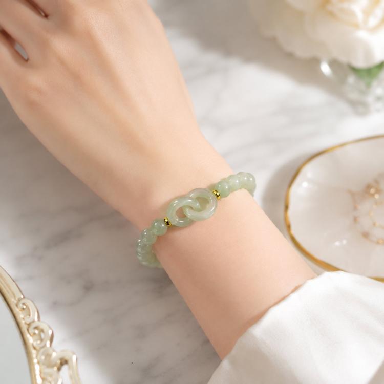 Green jade-style beaded bracelet with interlocking double loop centerpiece on wrist