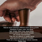 Hand holding solid wood handle stainless steel constant force coffee tamper