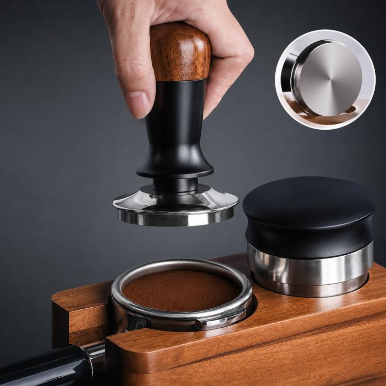 Coffee tamper with walnut wood handle and black body on a wooden base with portafilter