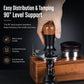 Coffee tamper with walnut wood handle and black body on a wooden base beside portafilter