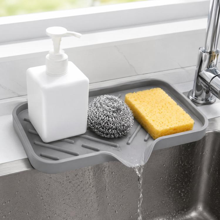 Gray silicone slanted sponge holder tray with drain spout and raised ridges for sink