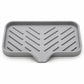 Gray slanted silicone sink tray with ridged grooves and central outlet for draining