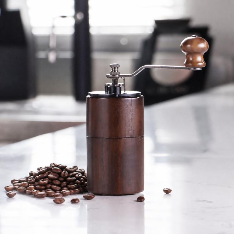 Dark wood hand-cranked coffee grinder with crank handle and metal grind assembly