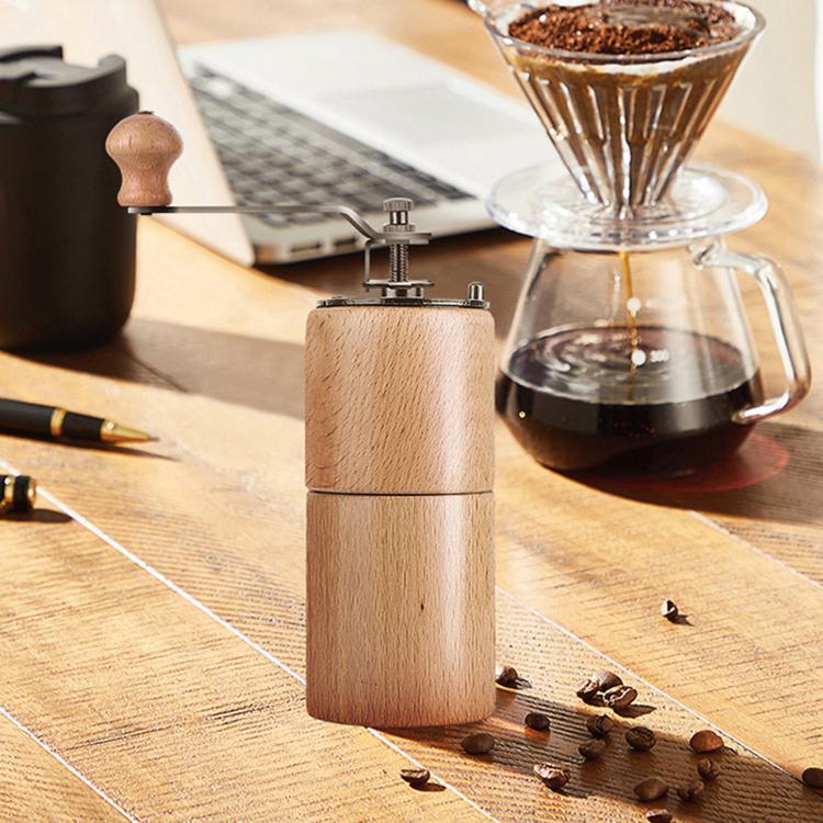 Hand-cranked wooden coffee grinder on countertop with visible crank and metal top