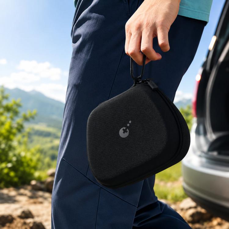 Hard-shell controller carrying case clipped to a backpack strap outdoors
