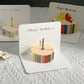 Birthday pop-up greeting card showing cake with candles and 'Happy Birthday' text