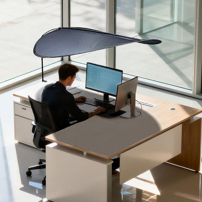 Indoor sunshade curtain in dark color over desk, attached to window with telescopic support