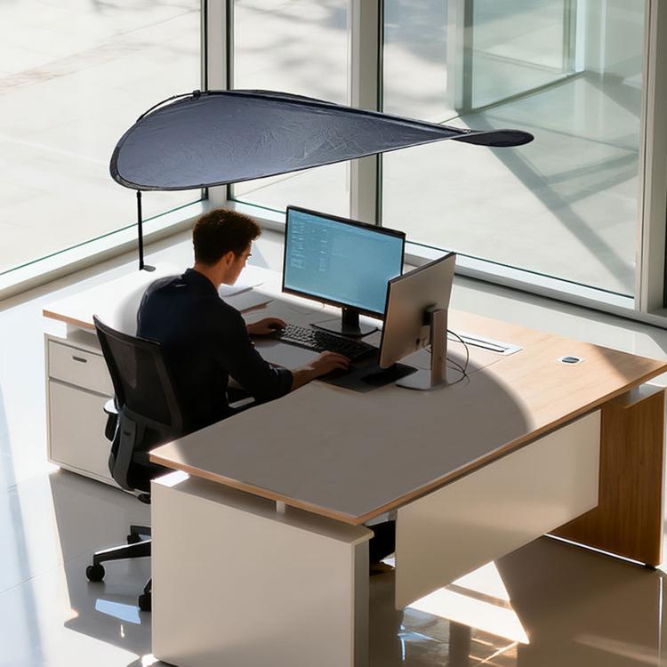 Indoor sunshade curtain in dark color over office desk, canopy-style shade near window