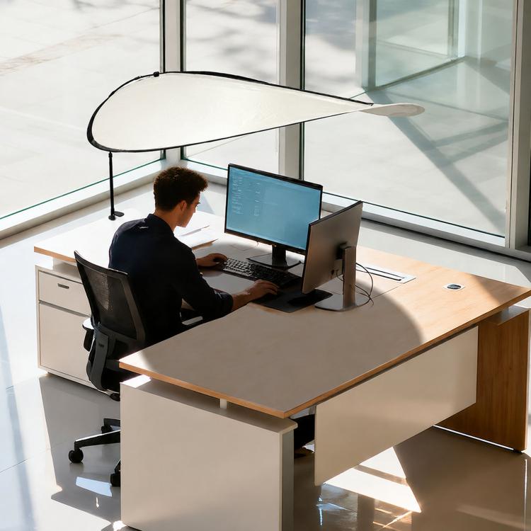 Indoor sunshade curtain in light color over office desk, curved canopy attached to pole