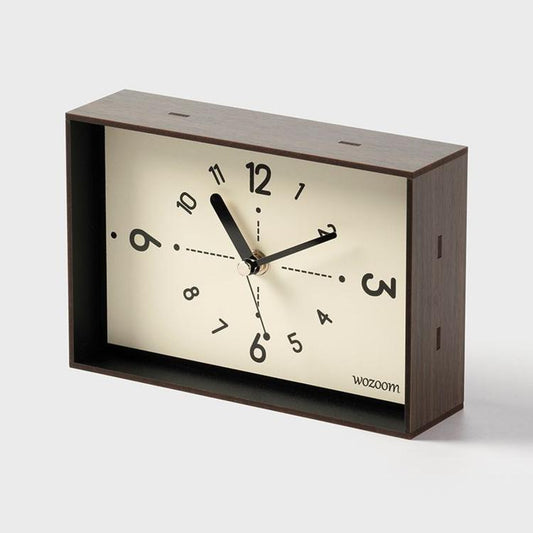 Dark woodgrain table clock with cream dial, black Arabic numerals, and black hands.